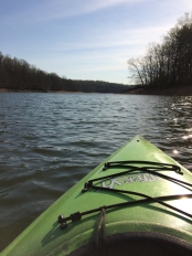 Photograph of the rippling, shimmering water of a lake as seen from a kayak